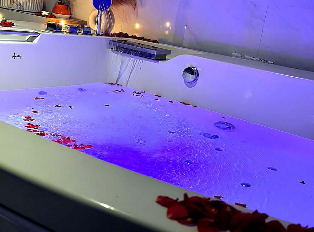 Jacuzzi with rose petals under mood lighting