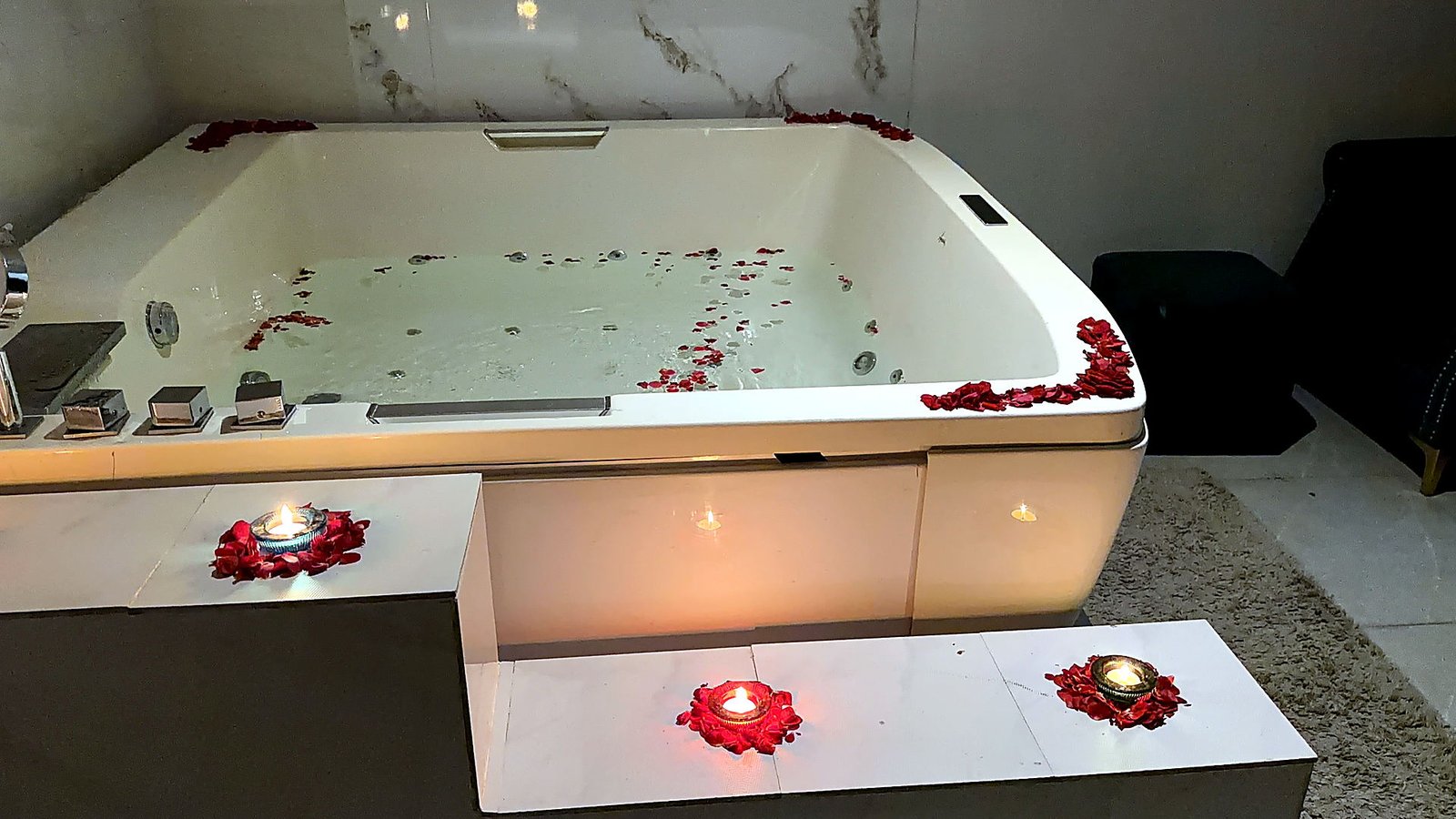Candle-lit jacuzzi with rose petals at Vaayu Wellness Spa